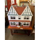 Large Elizabethan style dolls house with electric on portable stand.