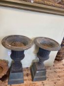 Pair of cast metal garden urns and stands, 86cm high.