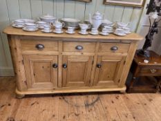 Pine dresser base having three frieze drawers above three cupboards on bun feet,