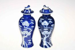 Pair Chinese baluster prunus vases with covers, double blue circle mark, 27cm.