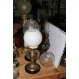 Five Victorian oil lamps including hand painted porcelain, brass ornate columns,