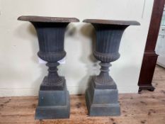 Pair cast Campana style garden urns on stepped tapered bases, 86cm by 47cm diameter.