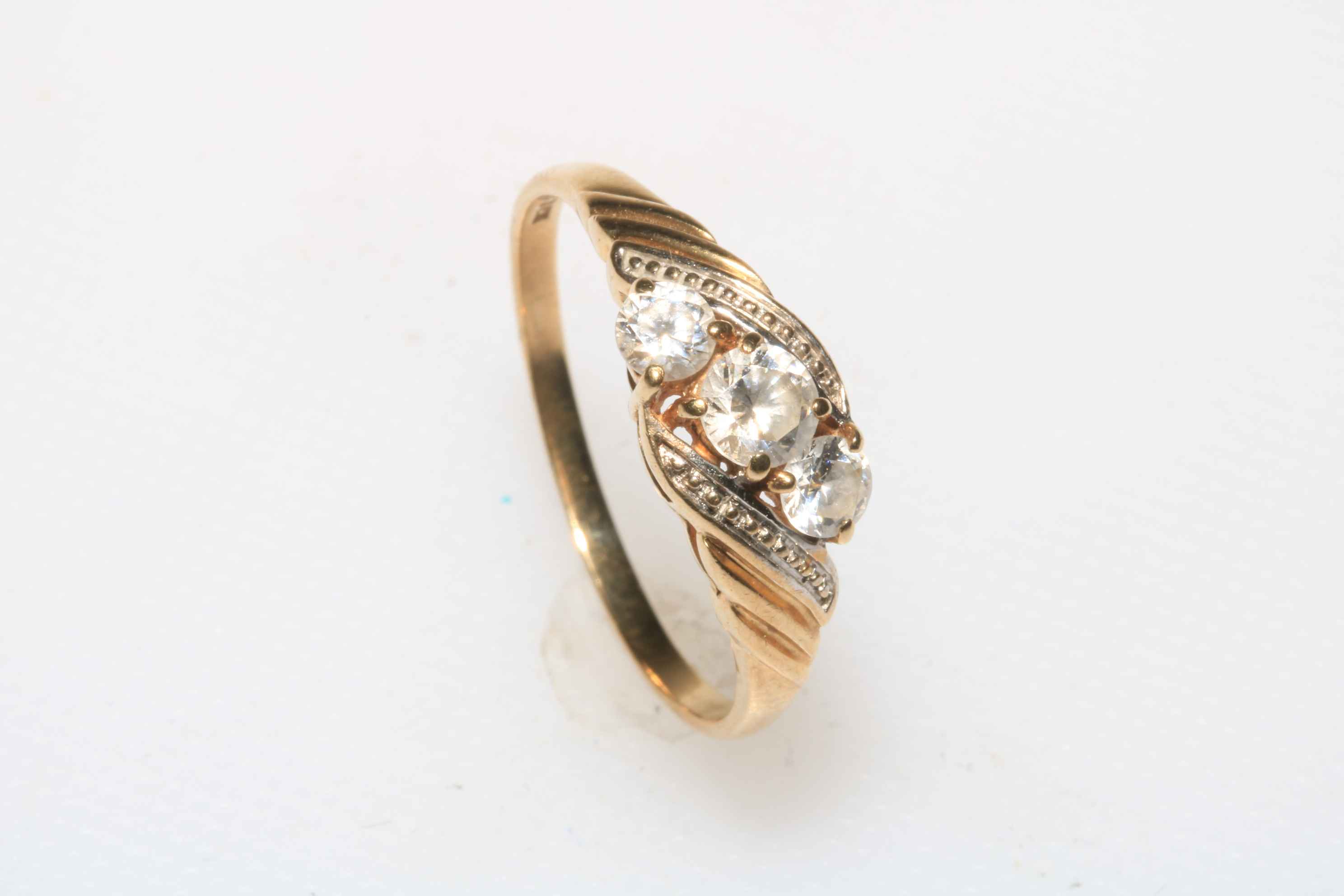 9 carat gold three white stone crossover ring, size T.