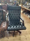 Black deep buttoned leather swivel office armchair.
