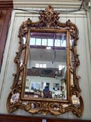 Ornate gilt framed marginal wall mirror, 127cm by 72.5cm.