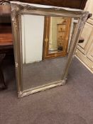 Silvered swept framed bevelled wall mirror, 106cm by 75cm overall.