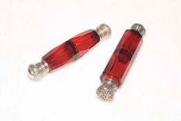 Two late Victorian cranberry glass double scent bottles.