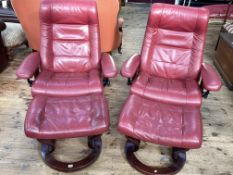Pair Ekornes Stressless adjustable armchairs and footstool in cherry leather.