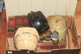 Box of vintage mining books, helmets and lamps.