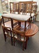 Oval rosewood extending dining table and eight chairs.