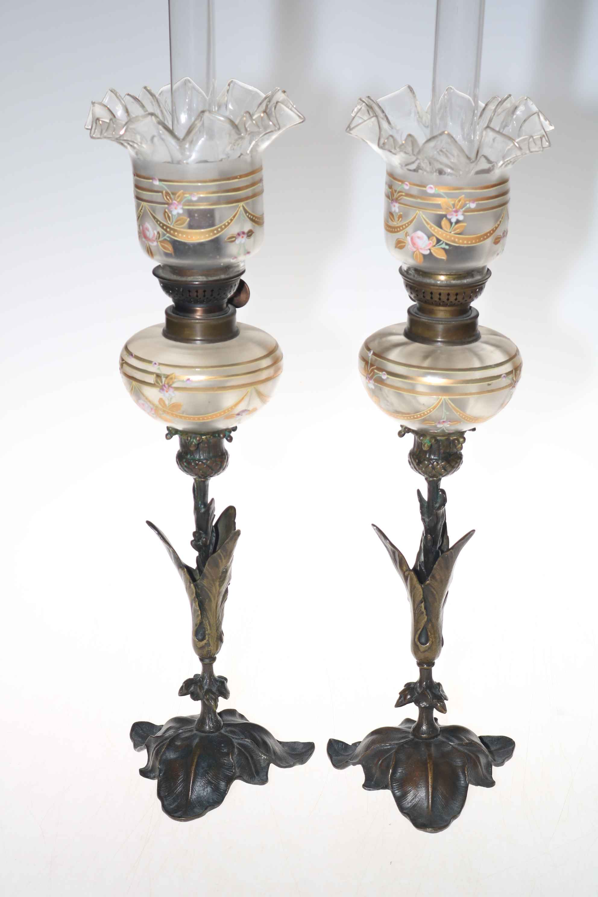 Pair of French leaf design metal based oil lamps with enamel and gilt decorated reservoir and