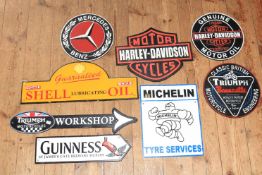 Collection of eight cast metal signs including Harley Davidson, Mercedes Benz, Triumph, Michelin,