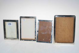 Four silver rectangular easel photograph frames.