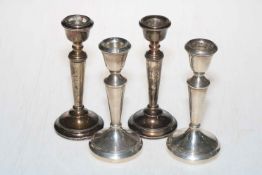 Two pairs of silver candlesticks.