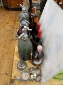 Four vintage soda siphons, wine and gin labels, wine funnel and taster.