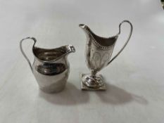 Two George III silver cream jugs with bright cut decoration.