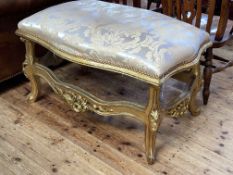 Large gilt stool of serpentine form, 62cm by 107cm by 73cm.