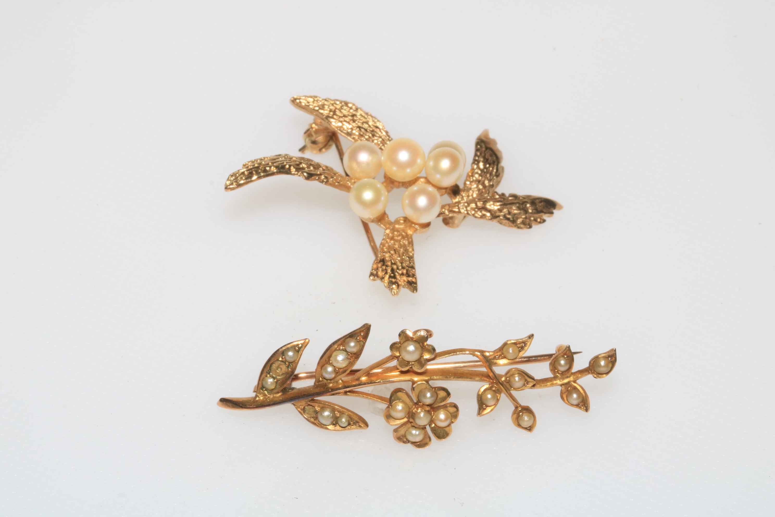 Two 9 carat gold pearl set brooches.