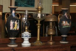 Three oil lamps including two brass Art Nouveau and a German porcelain,