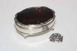 Silver and tortoiseshell oval ring box with ornate border, Birmingham 1927, and silver ship brooch,