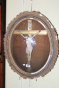 19th Century crucifix in oval gilt frame behind domed glass, 50cm by 40cm.