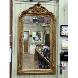 Gilt framed arched top bevelled wall mirror with foliate crest, 155cm by 85.5cm including frame.