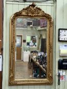 Gilt framed arched top bevelled wall mirror with foliate crest, 155cm by 85.5cm including frame.