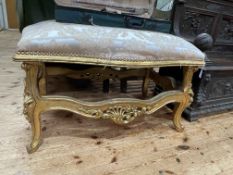 Large gilt stool of serpentine form, 62cm by 107cm by 73cm.