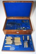 Oak cutlery box containing a selection of cutlery.
