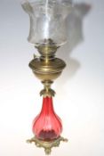 Victorian ruby glass and brass oil lamp with etched shade, 74cm high.
