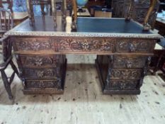 Late Victorian heavily carved oak nine drawer pedestal desk with lion mask handles, 78.