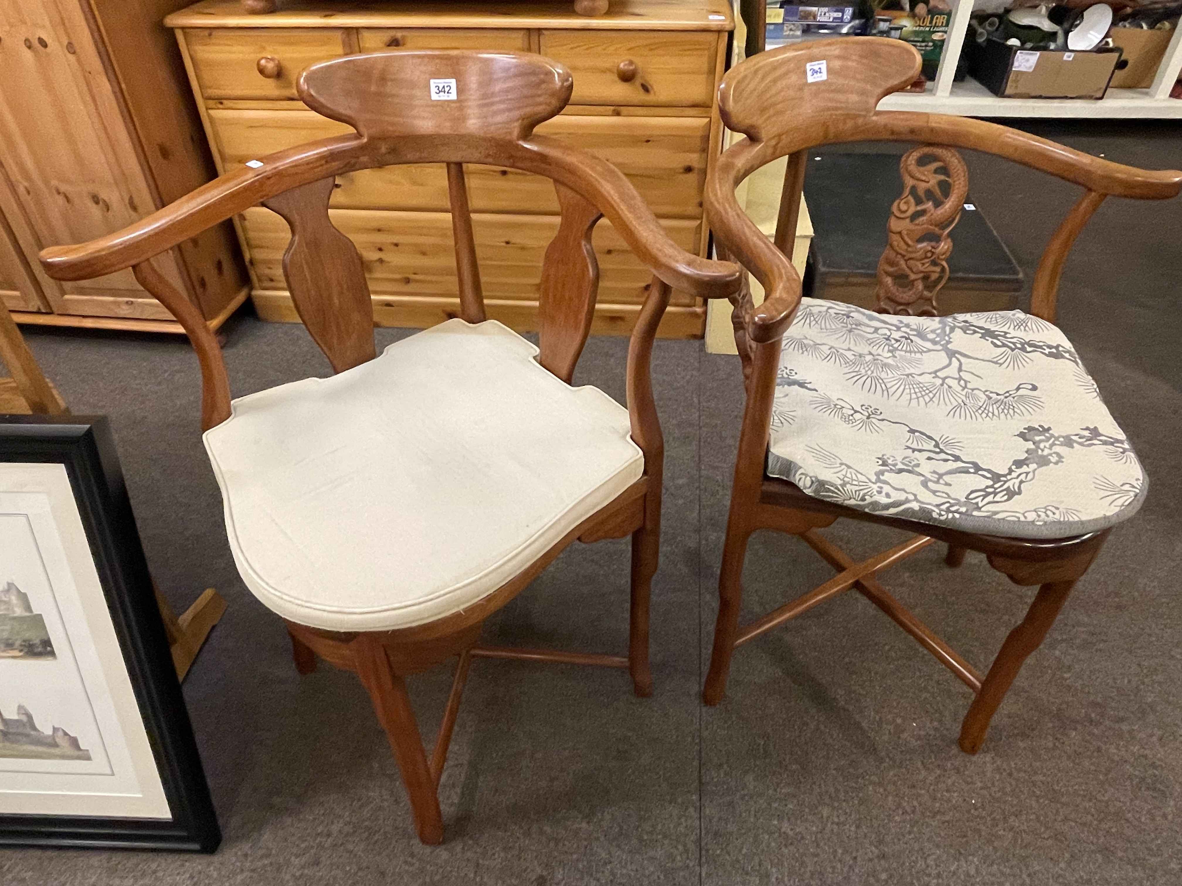 Two Oriental style hardwood corner elbow chairs.