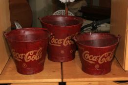 Three marked Coca Cola buckets.