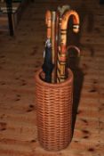 Wicker umbrella stand with walking canes including one silver collared.