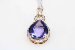 Diamond and tanzanite pendant set with pear shaped tanzanite in raised claw setting with 62