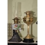 Two Victorian oil lamps including floral painted reservoir and a brass stemmed on a plinth base.