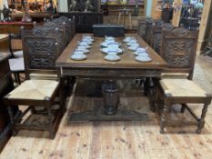 Oak parquetry topped and carved base draw leaf dining table and eight rush seated carved panel back