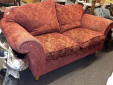 Two seater settee in red classical pattern fabric.