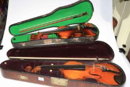 Two cased violins with bows.