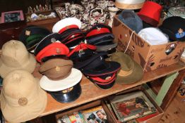 A very good collection of military helmets, berets, Officers peaked hats, belts,