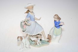 Two Lladro and one Nao figurine depicting dogs.