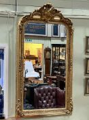 Rectangular gilt framed bevelled wall mirror with foliate crest, 155.5cm by 83cm.