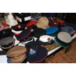 A very good collection of military helmets, berets, Officers peaked hats, belts, flags,
