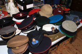 A very good collection of military helmets, berets, Officers peaked hats, belts, flags,