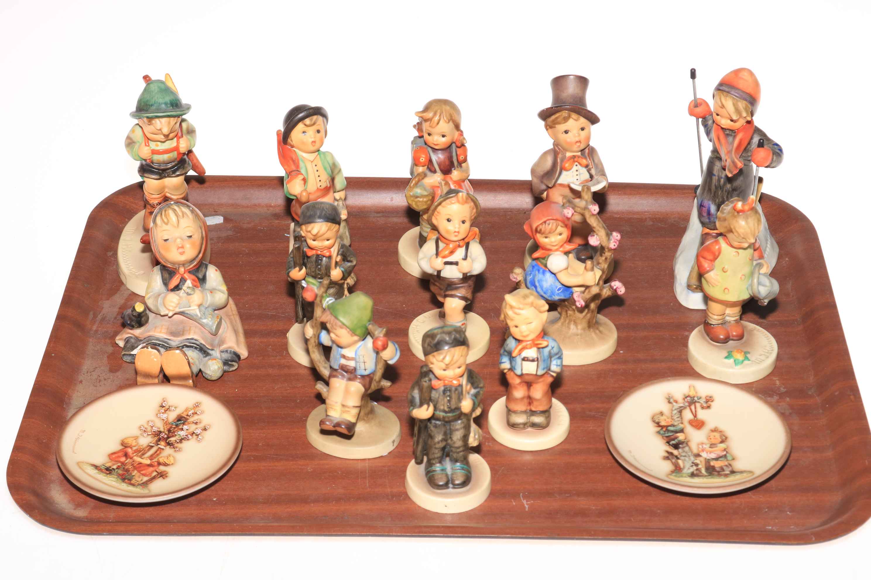 Thirteen Hummel figurines and two Hummel plates.