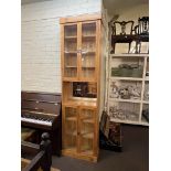 Tall pine glazed four door cabinet, 232cm by 65cm by 27cm.
