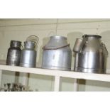 Four aluminium milk churns.