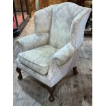 Wing armchair on ball and claw legs in light classical fabric.