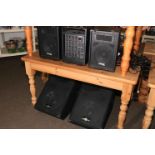 Seven various amplifiers and a collection of guitar stands.