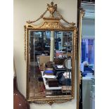 Rectangular gilt framed bevelled wall mirror with urn and garland crest, 116cm by 61cm.